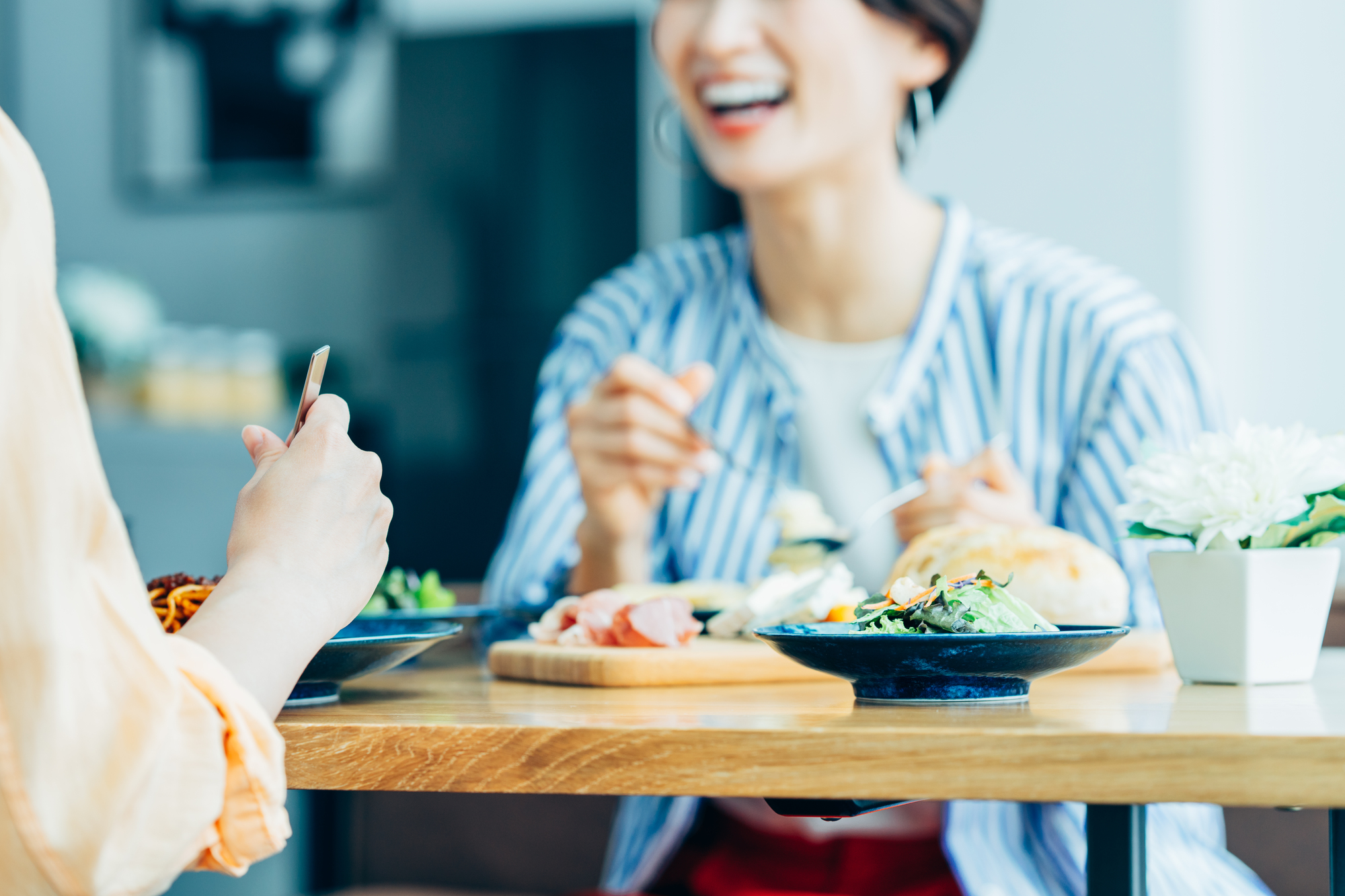食事をしながら会話をする女性