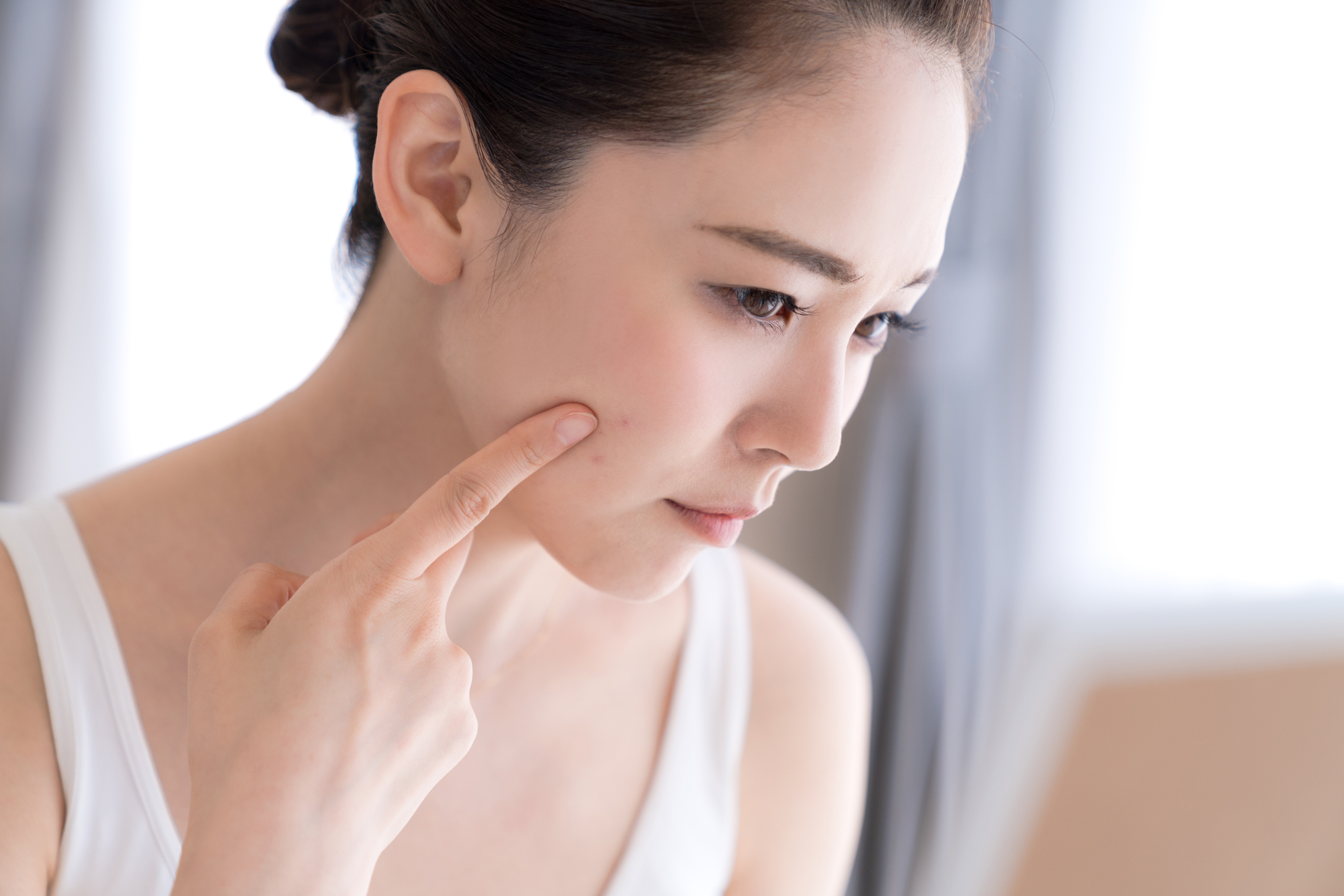 指で顔を触る女性