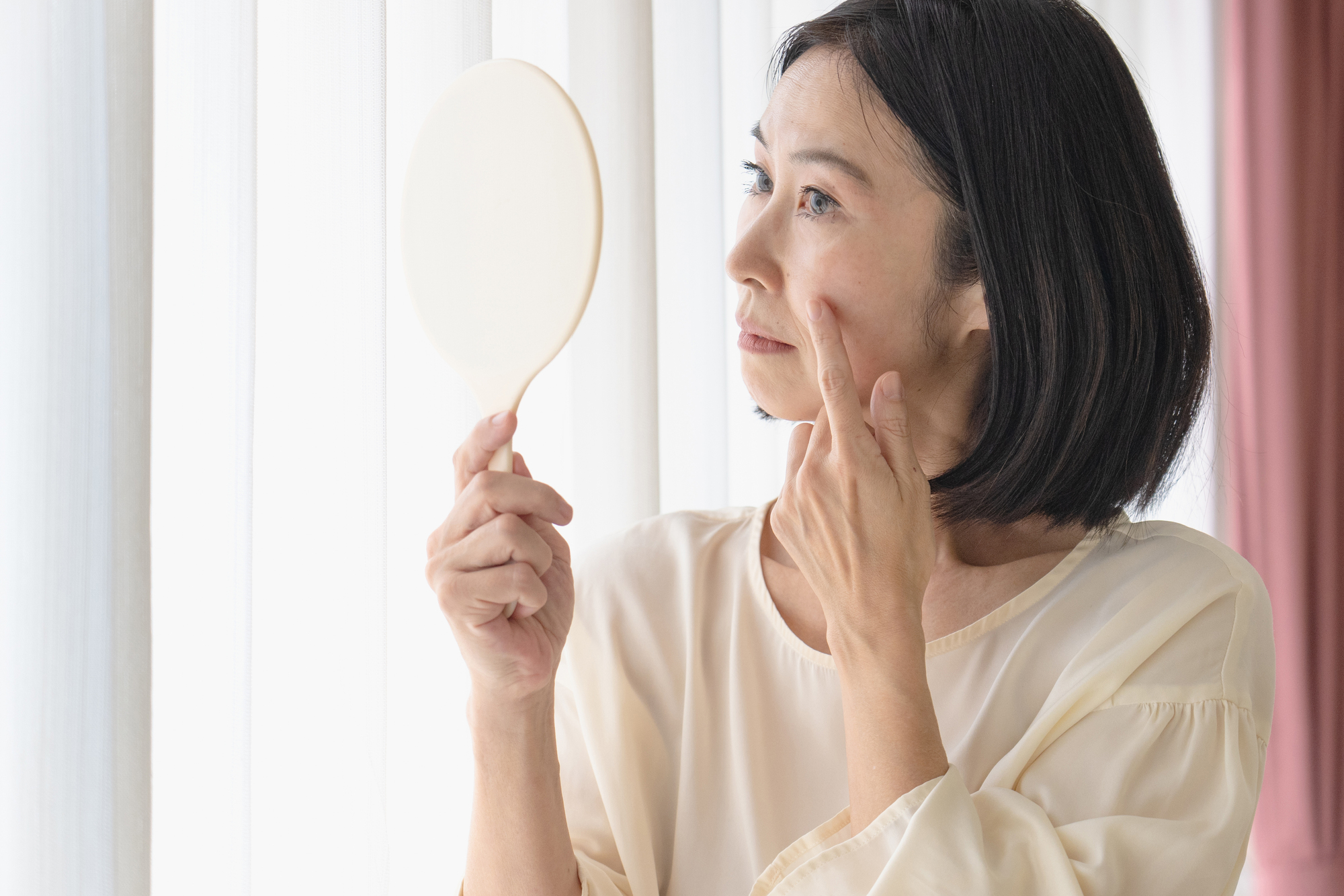 顔を確認する女性の画像