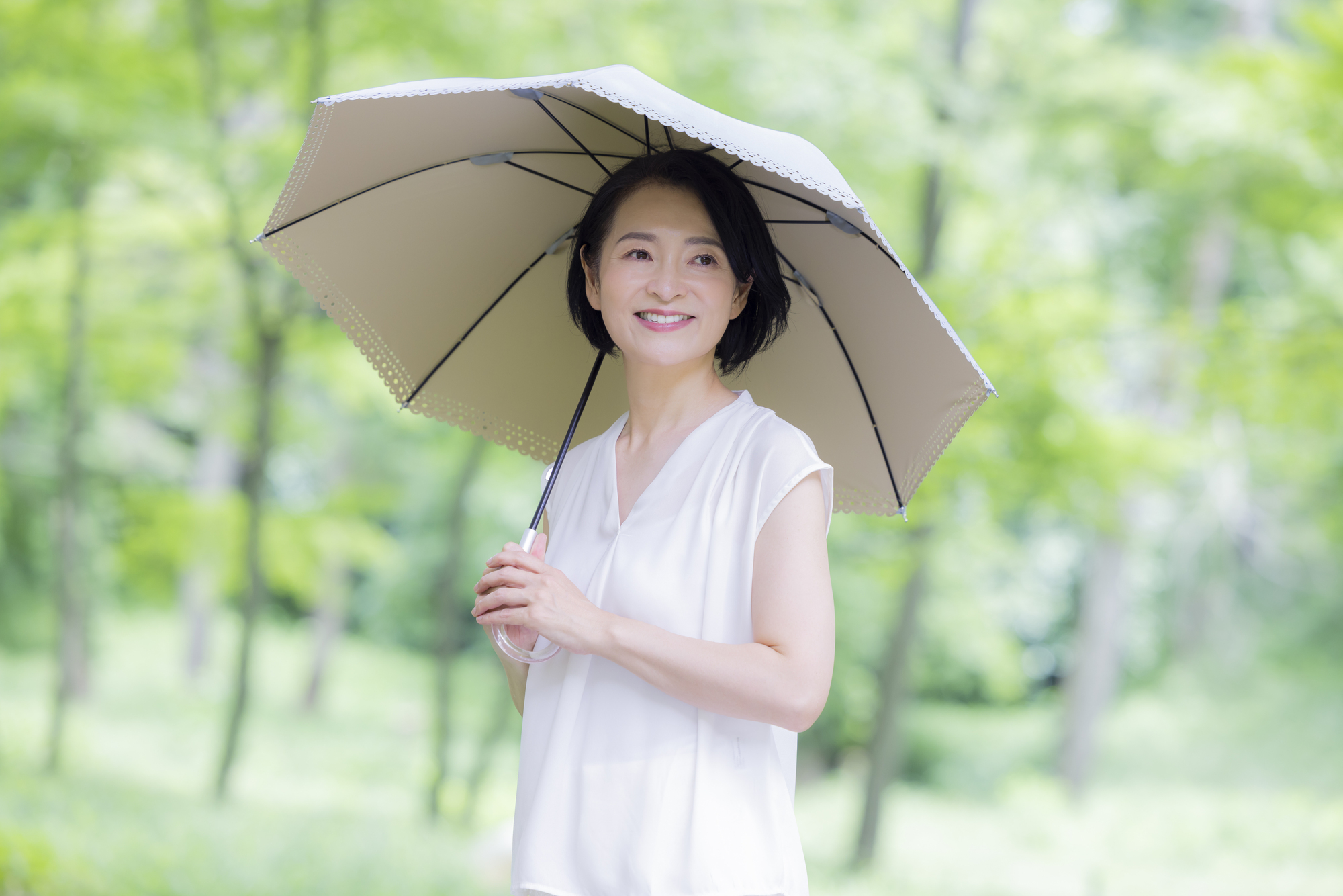 日傘をさす女性の画像
