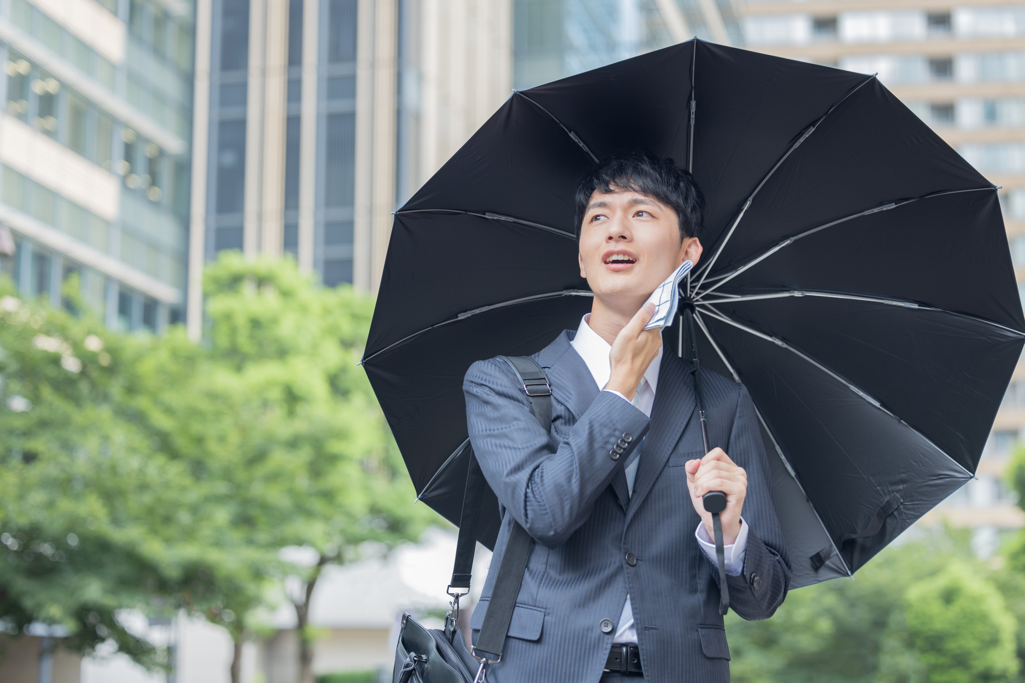 日傘をする男性の画像