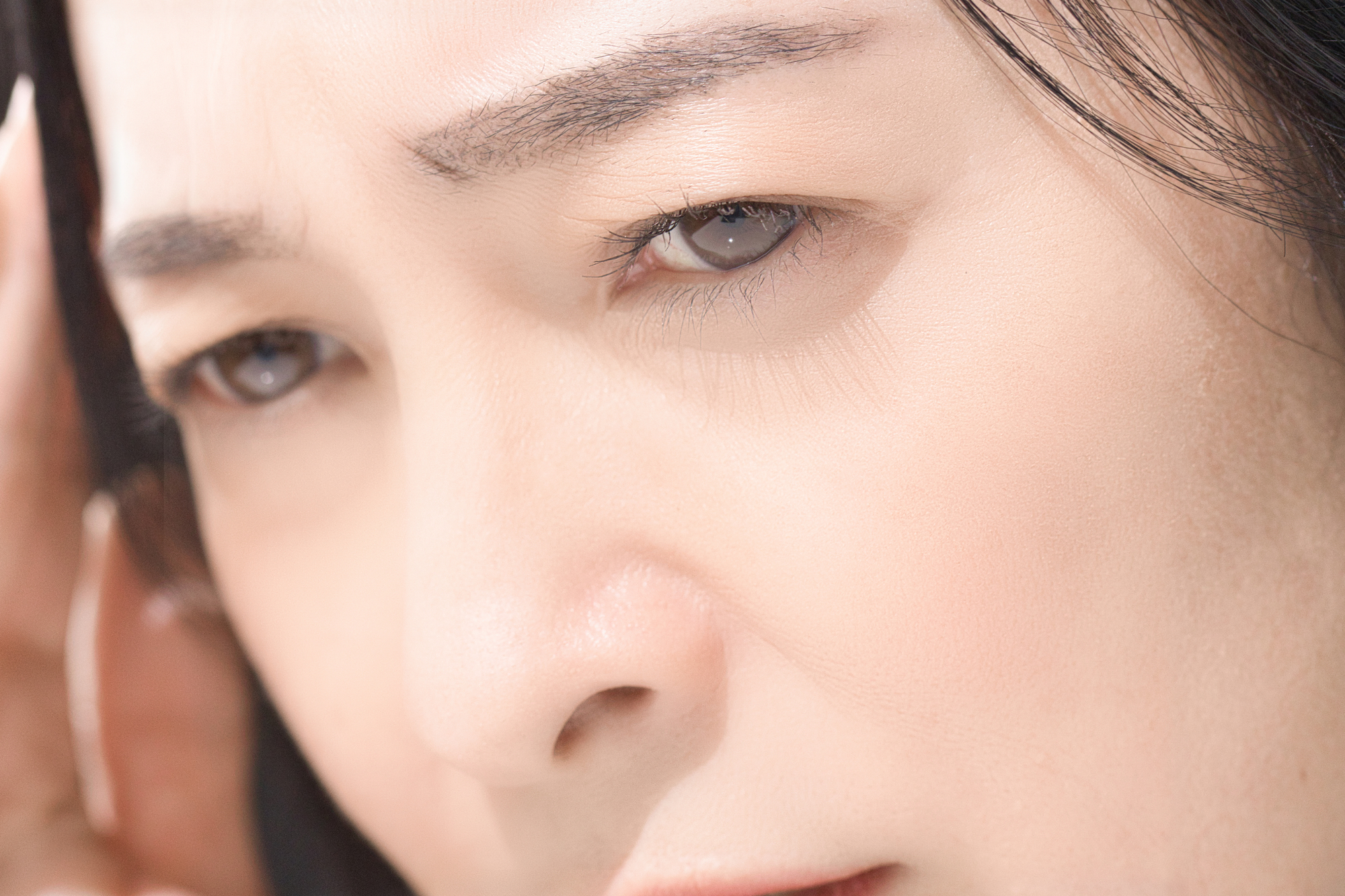こめかみを抑える女性の画像