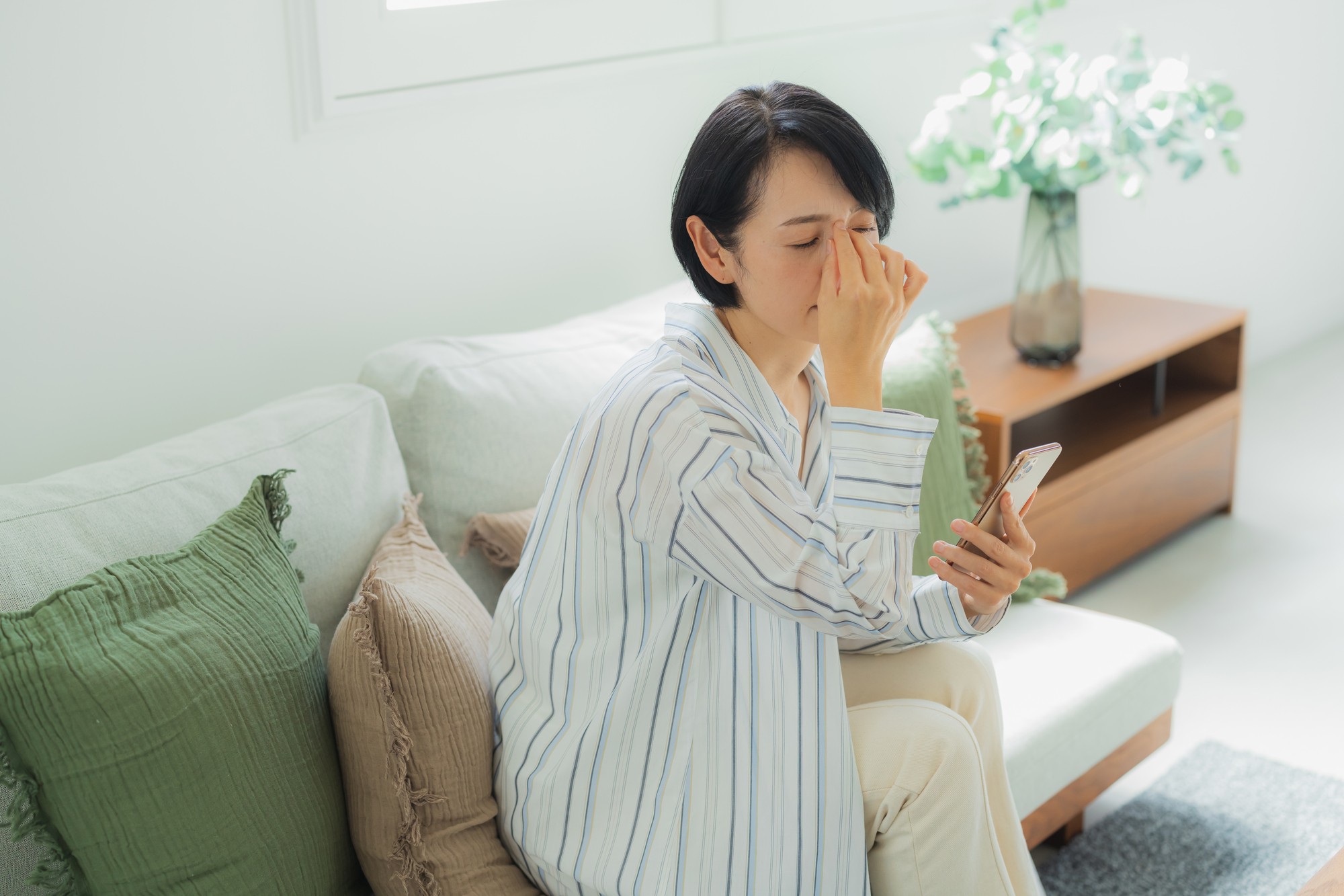 眼を抑える女性の画像