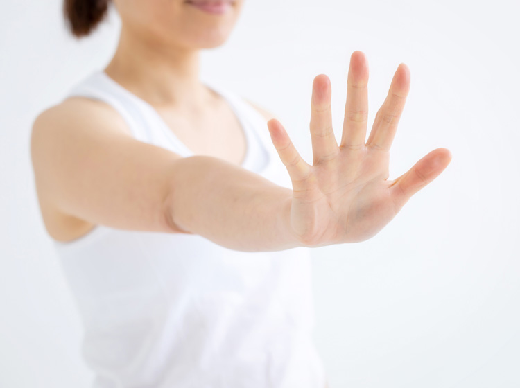 手を前に出し拒否する女性
